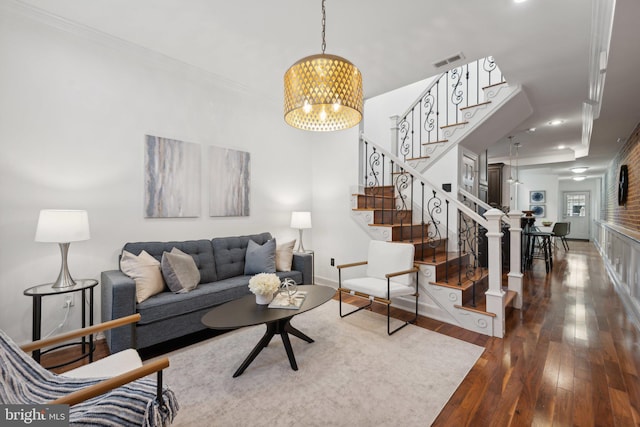 living room featuring ornamental molding, hardwood / wood-style flooring, and a notable chandelier