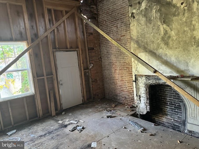 miscellaneous room featuring a fireplace and brick wall