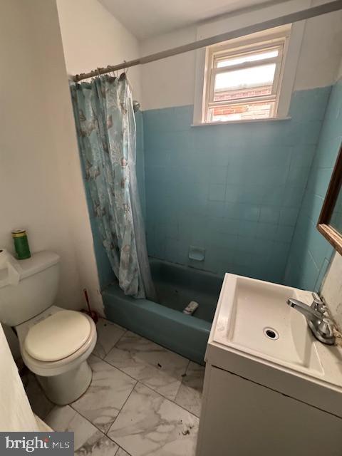 full bathroom with shower / tub combo with curtain, vanity, and toilet