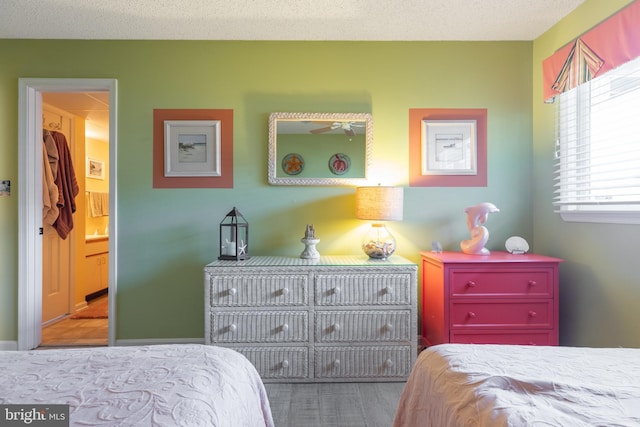 bedroom with a textured ceiling and ensuite bath