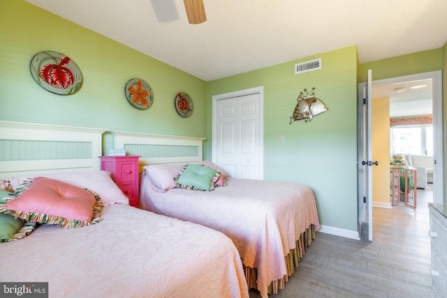 bedroom featuring hardwood / wood-style flooring, ceiling fan, vaulted ceiling, and a closet