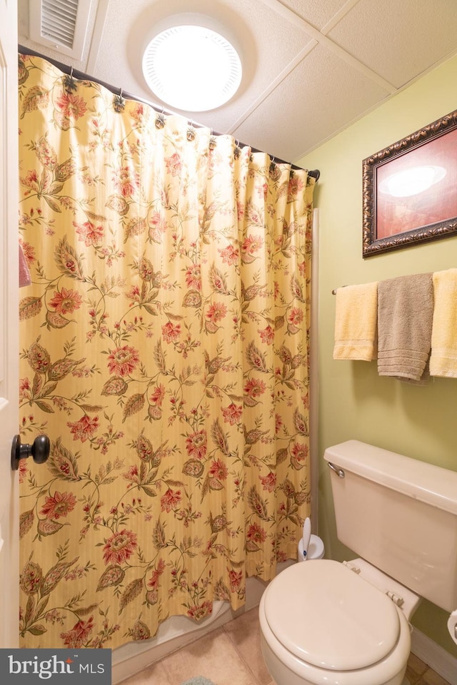 bathroom with tile patterned floors, a shower with shower curtain, and toilet