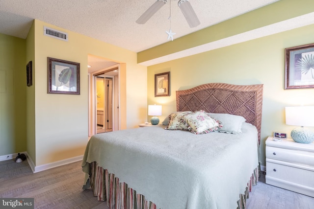 bedroom with a textured ceiling, light wood-type flooring, and ceiling fan