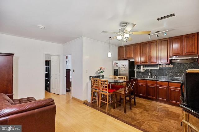 kitchen with light wood-type flooring, backsplash, ceiling fan, sink, and stainless steel fridge with ice dispenser