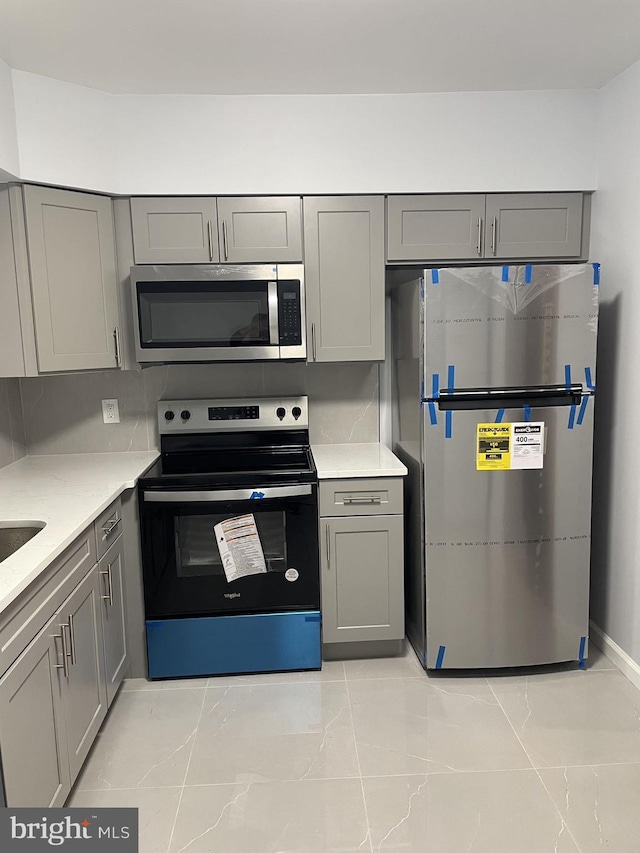 kitchen with stainless steel appliances and gray cabinets