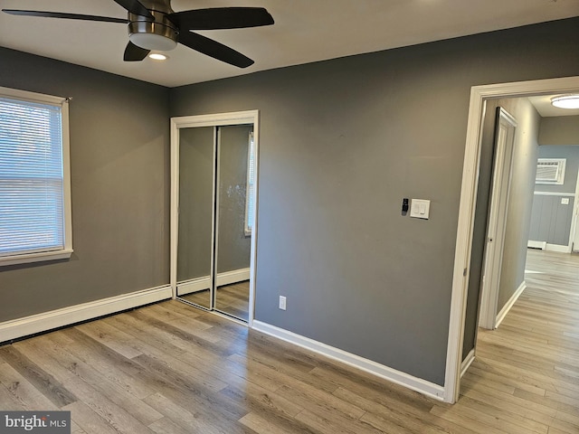 unfurnished bedroom with ceiling fan, light wood-type flooring, and a closet