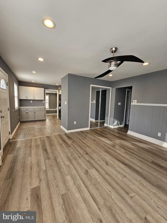 unfurnished living room featuring ceiling fan and light hardwood / wood-style flooring