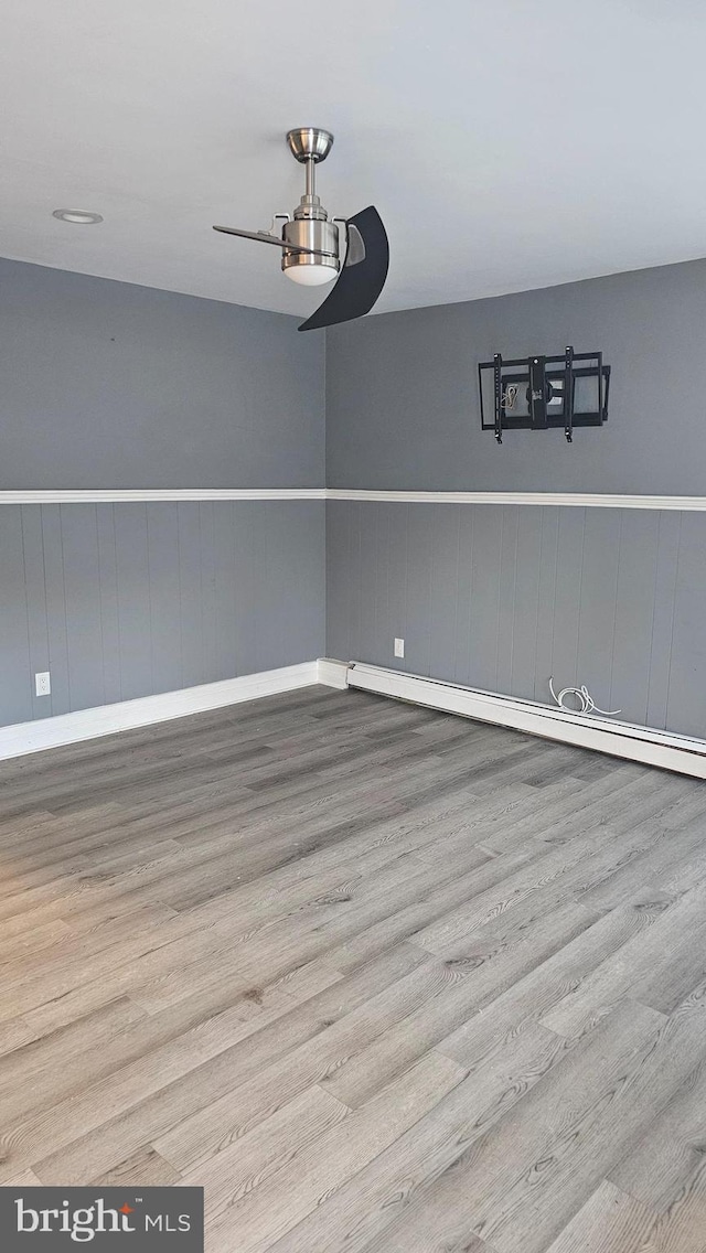 unfurnished dining area with ceiling fan, light hardwood / wood-style flooring, and a baseboard heating unit