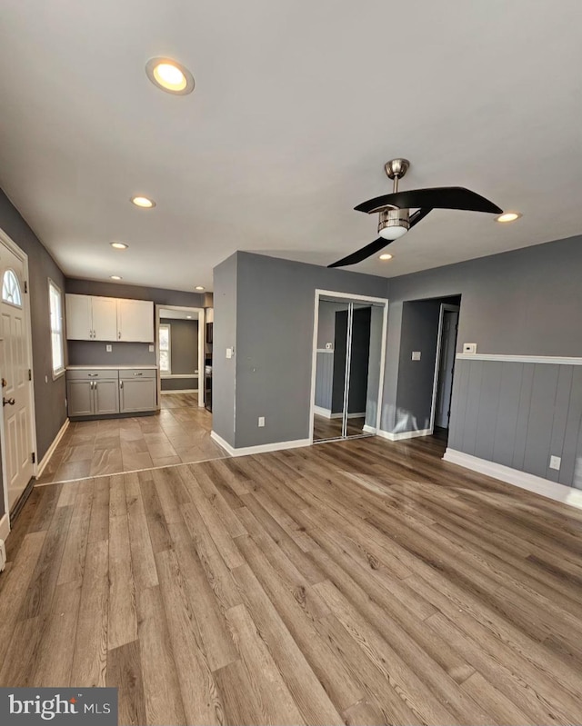 unfurnished living room with ceiling fan and light hardwood / wood-style flooring