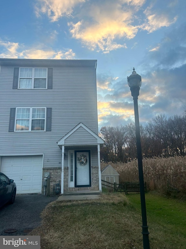 view of front of property with a garage and a lawn