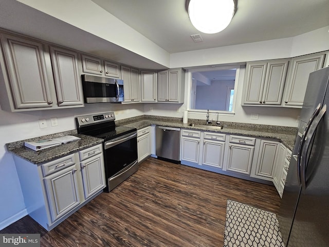 kitchen with dark hardwood / wood-style flooring, sink, gray cabinets, and appliances with stainless steel finishes