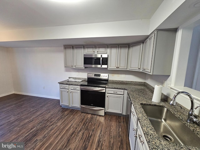 kitchen with gray cabinetry, sink, appliances with stainless steel finishes, and dark wood-type flooring