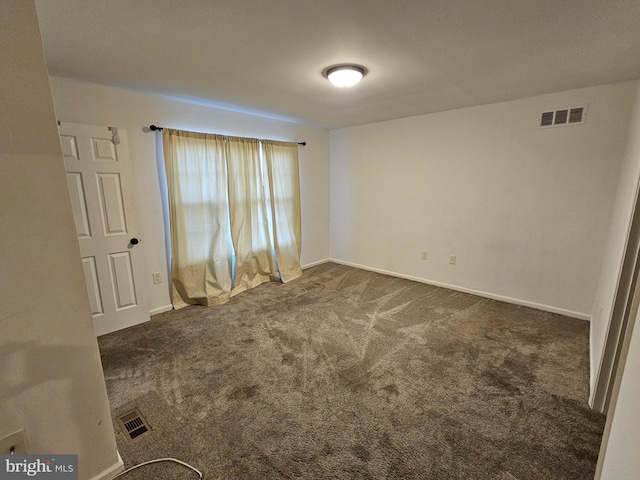 unfurnished room featuring dark colored carpet