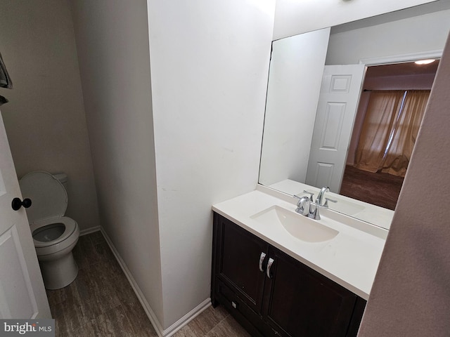 bathroom featuring hardwood / wood-style floors, vanity, and toilet