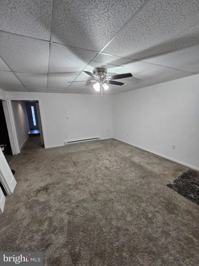 carpeted empty room with ceiling fan, a drop ceiling, and a baseboard radiator