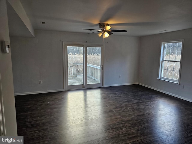 empty room with ceiling fan, dark hardwood / wood-style flooring, and a healthy amount of sunlight