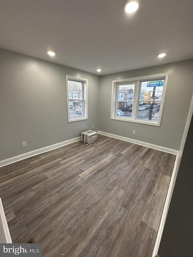 empty room with dark wood-type flooring and a healthy amount of sunlight