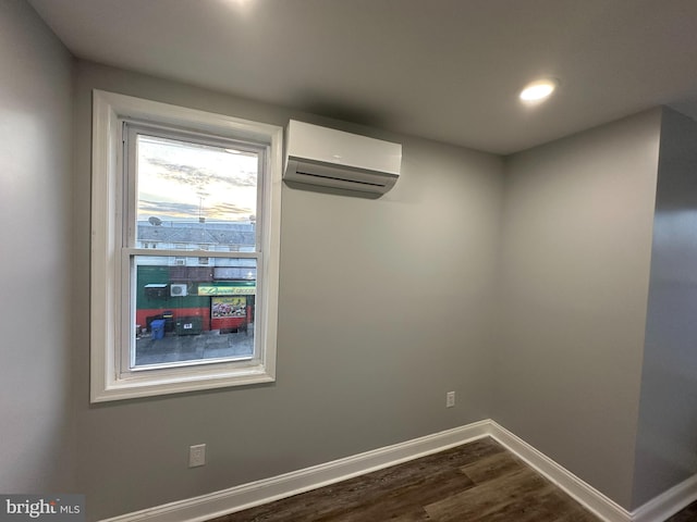 spare room with dark hardwood / wood-style flooring and a wall unit AC