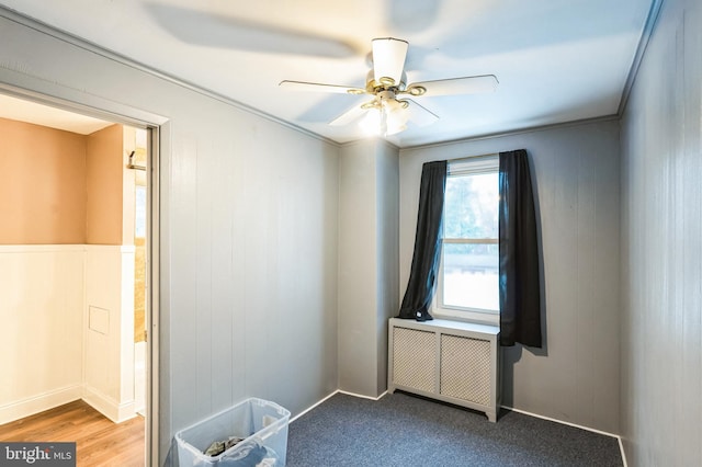 spare room with hardwood / wood-style floors, ceiling fan, ornamental molding, and radiator