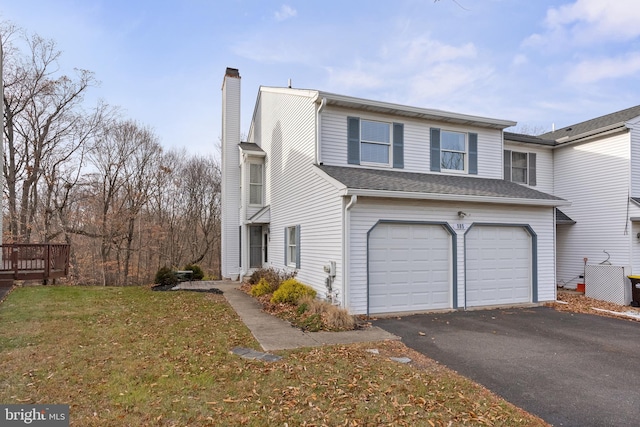 view of side of property featuring a garage and a lawn