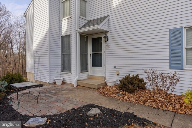 view of exterior entry with a patio