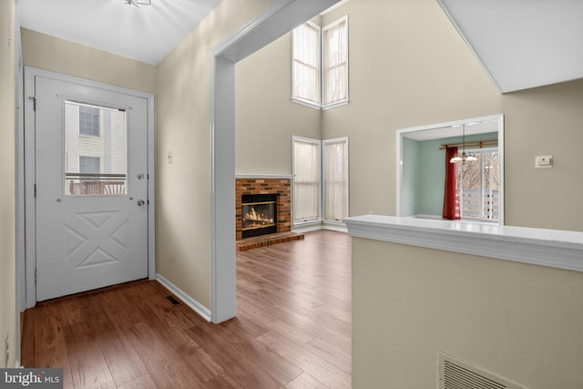 entryway featuring a brick fireplace, plenty of natural light, and hardwood / wood-style flooring