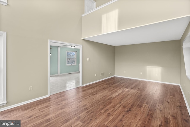 unfurnished room with wood-type flooring and a high ceiling