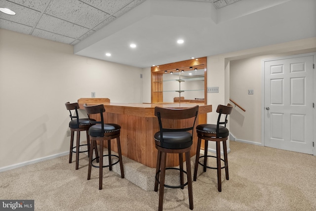 bar with a drop ceiling and light colored carpet