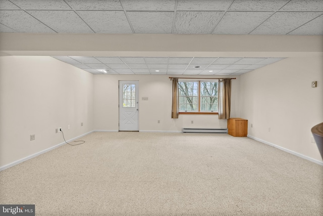 empty room featuring carpet flooring, a paneled ceiling, and a baseboard radiator