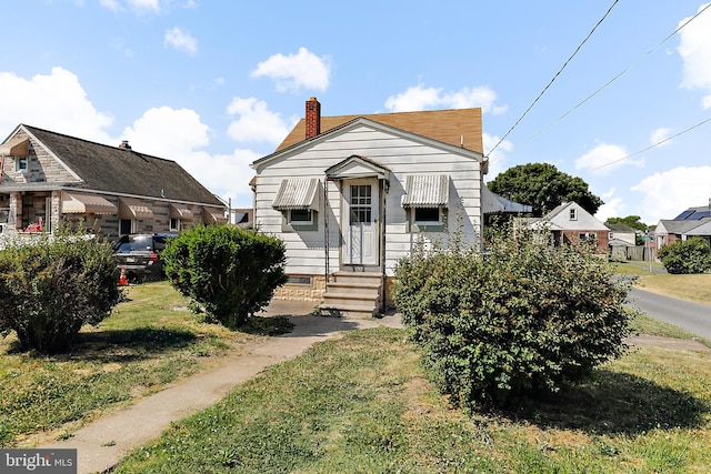 bungalow-style home with a front lawn