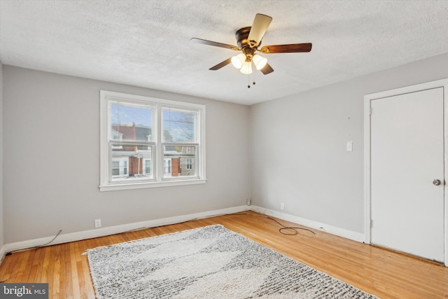 empty room featuring ceiling fan, a textured ceiling, and light wood-type flooring