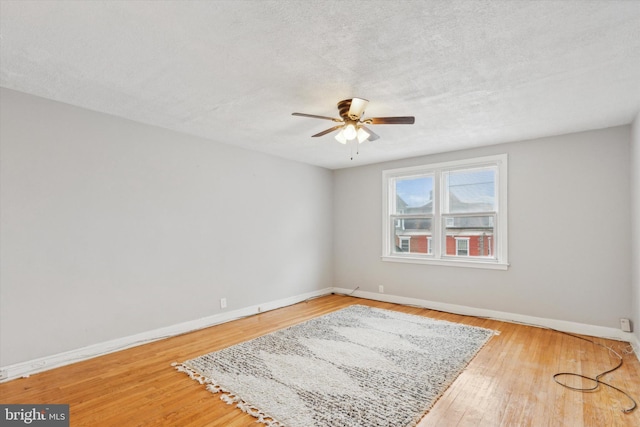 spare room featuring hardwood / wood-style flooring, ceiling fan, and a textured ceiling