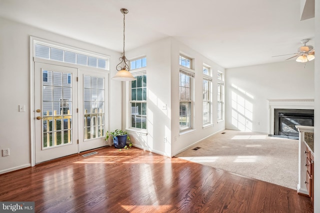 unfurnished living room with hardwood / wood-style flooring and ceiling fan