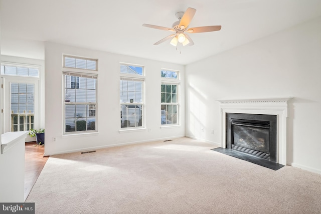 unfurnished living room featuring light carpet and a wealth of natural light