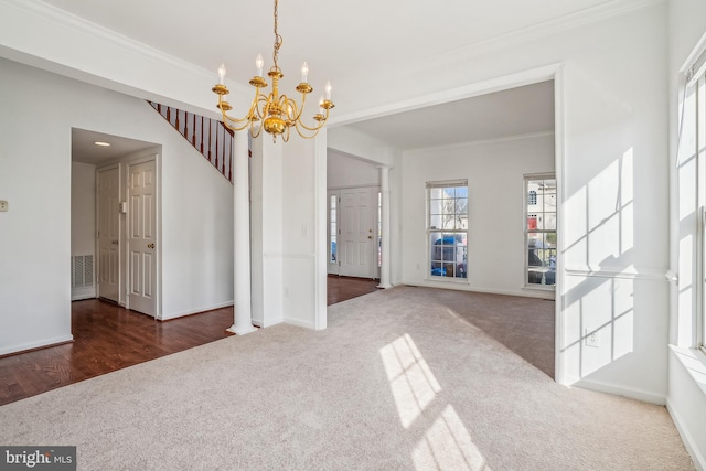 unfurnished dining area with ornamental molding, a chandelier, and dark carpet