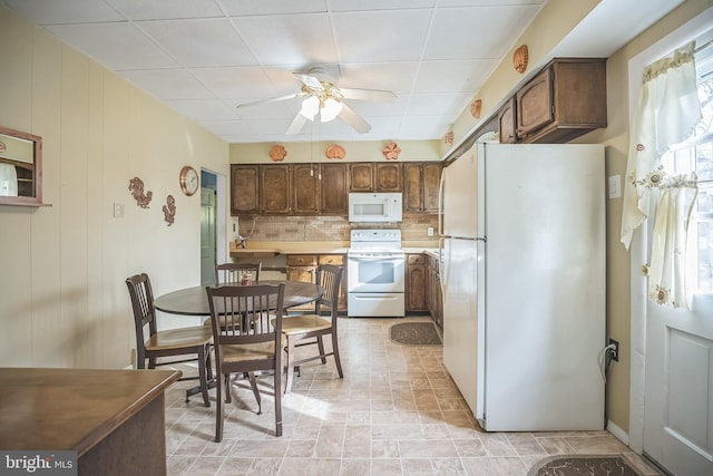 kitchen featuring decorative backsplash, ceiling fan, dark brown cabinetry, and white appliances