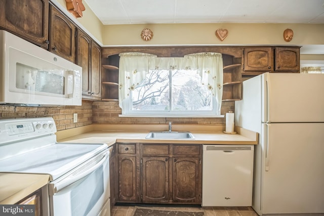 kitchen featuring decorative backsplash, white appliances, dark brown cabinetry, and sink