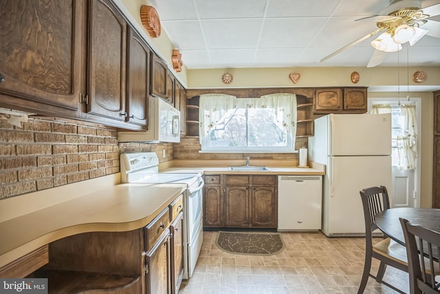 kitchen featuring backsplash, plenty of natural light, white appliances, and sink