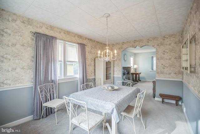 carpeted dining area featuring an inviting chandelier