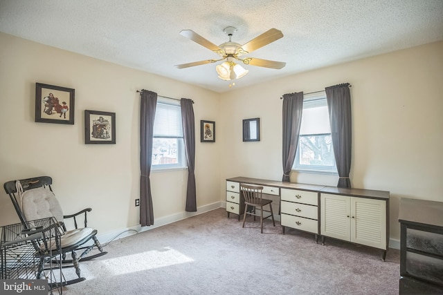 office featuring a textured ceiling, light colored carpet, and ceiling fan