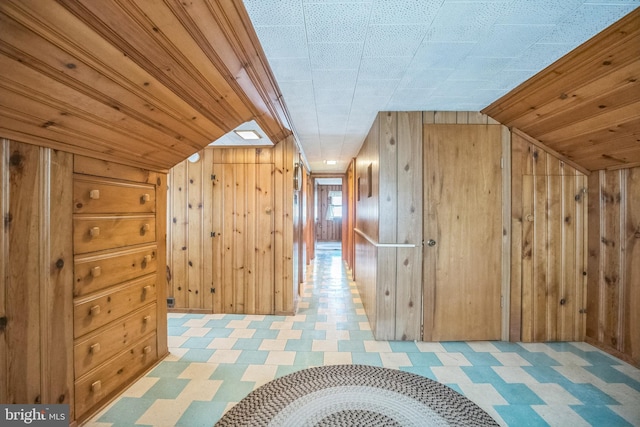 additional living space featuring wooden walls and vaulted ceiling