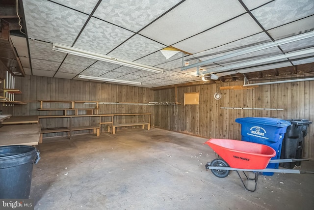 garage featuring a garage door opener and wooden walls