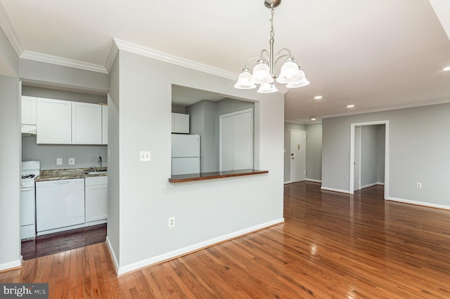 kitchen with white appliances, dark wood-type flooring, white cabinets, hanging light fixtures, and a notable chandelier