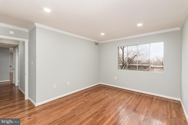 spare room featuring hardwood / wood-style flooring and ornamental molding