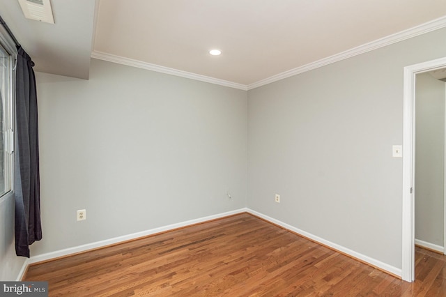 spare room with crown molding and hardwood / wood-style flooring