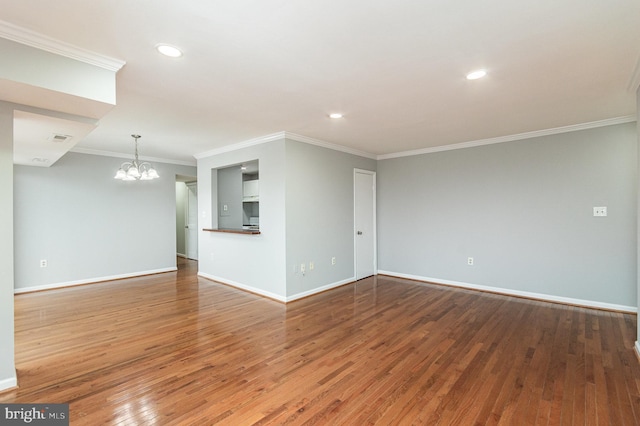 unfurnished living room with hardwood / wood-style floors, crown molding, and an inviting chandelier