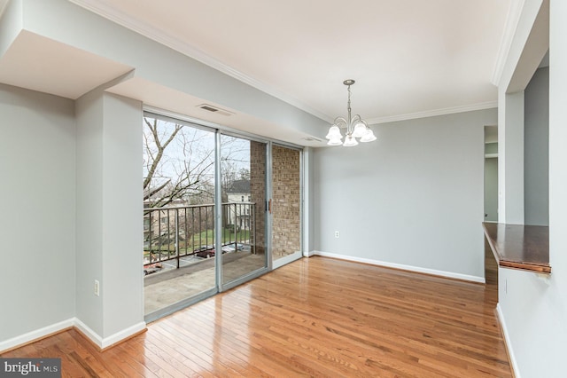 unfurnished dining area featuring hardwood / wood-style floors, an inviting chandelier, and ornamental molding