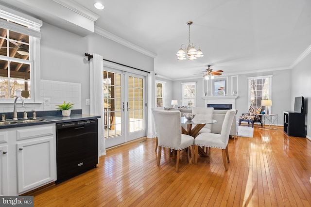 dining room featuring sink, ceiling fan with notable chandelier, light wood-type flooring, and crown molding