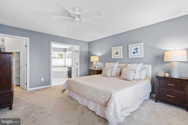 bedroom with ceiling fan, light carpet, and connected bathroom