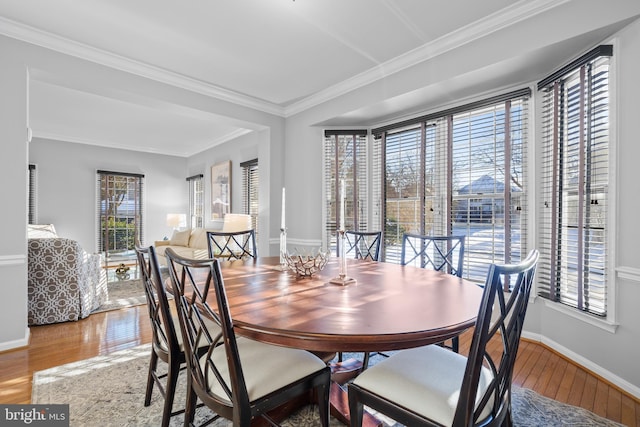 dining space featuring wood-type flooring and ornamental molding